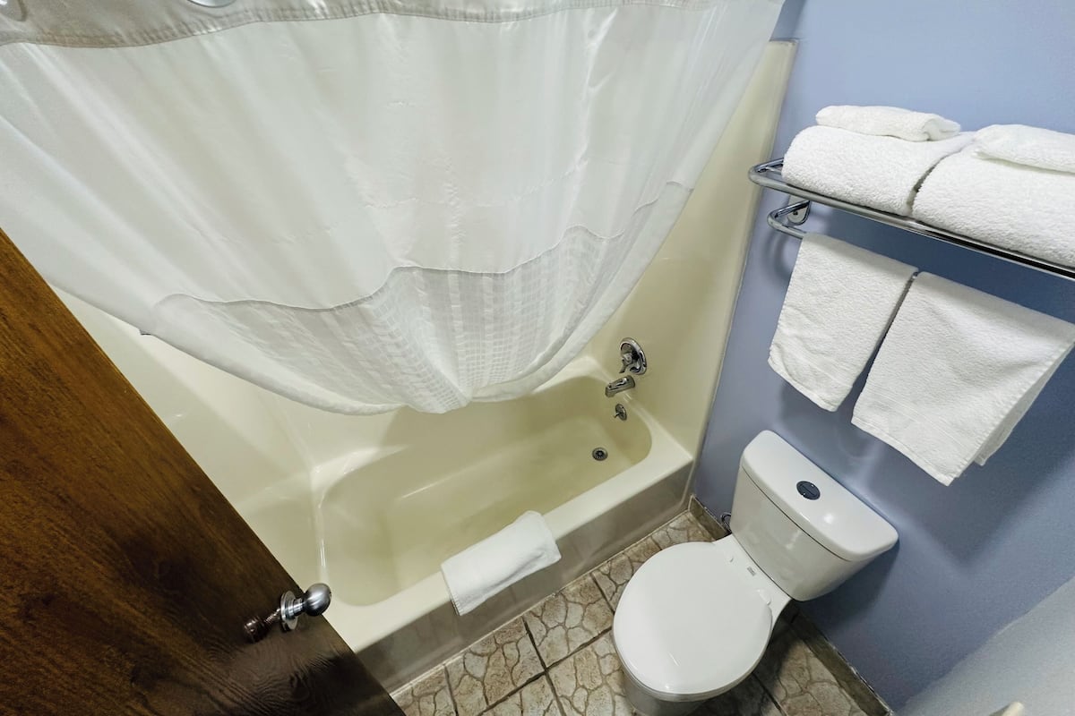 Ein Badezimmer mit Badewanne, Toilette und Handtuchhalter.