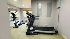 A gym with a treadmill, stationary bike, and elliptical machine. - Super 8 by Wyndham Imlay City (Imlay City)