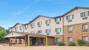 A multi-story hotel with a covered entrance and a brick facade. - Super 8 by Wyndham St. Clair MO (St. Clair)