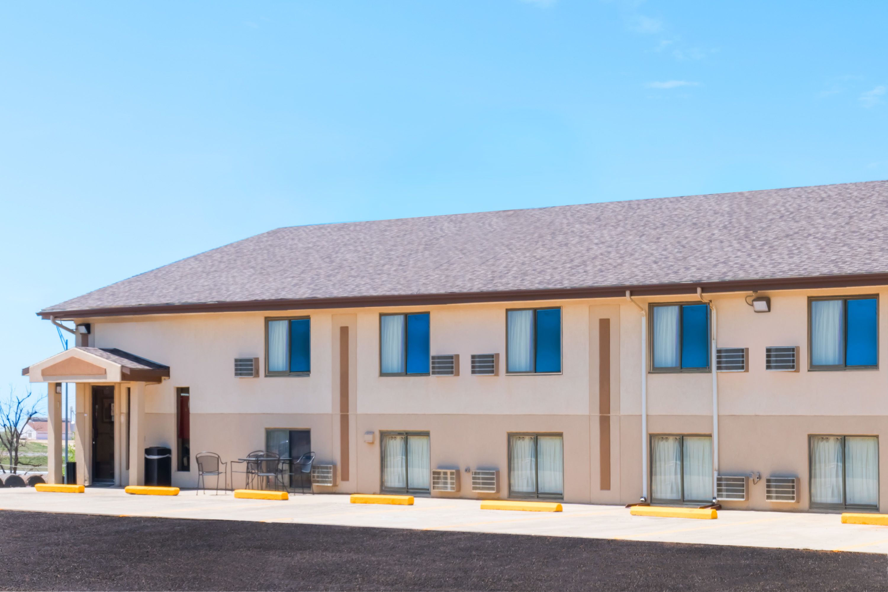 Un hotel de varios pisos con techo plano, amplias ventanas y una zona de entrada cubierta.