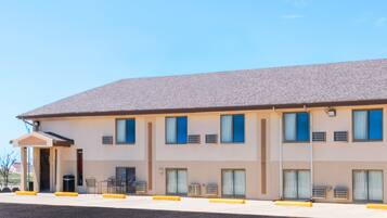 A multi-story hotel with a flat roof, large windows, and a covered entrance area.