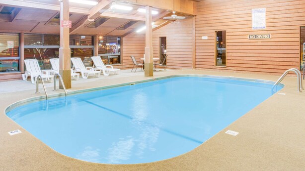 An indoor swimming pool with lounge chairs and a 'NO DIVING' sign.