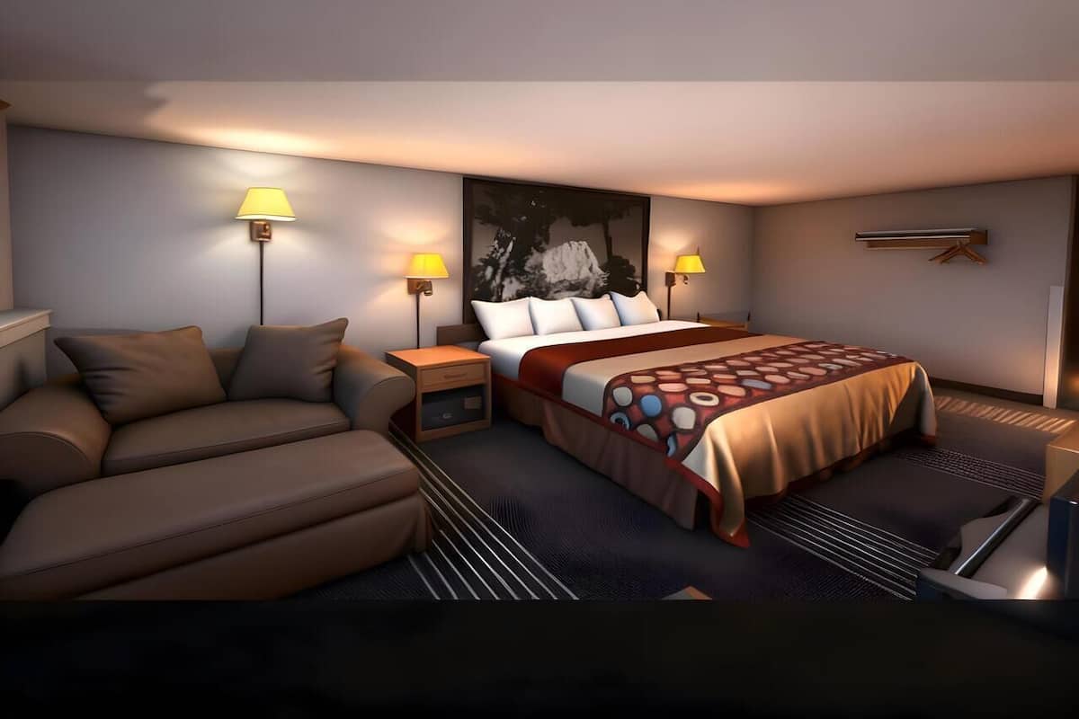Ein modernes Hotelzimmer mit einer Couch, einem Bett mit gemustertem Überwurf, zwei Nachttischlampen und einem großen abstrakten Gemälde an der Wand.