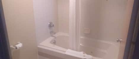 Un baño con bañera, inodoro y cortina de ducha.