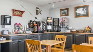 A kitchen with a coffee machine, a milk dispenser, and various food items on the counter. - Super 8 by Wyndham Baxter/Brainerd Area (Baxter)