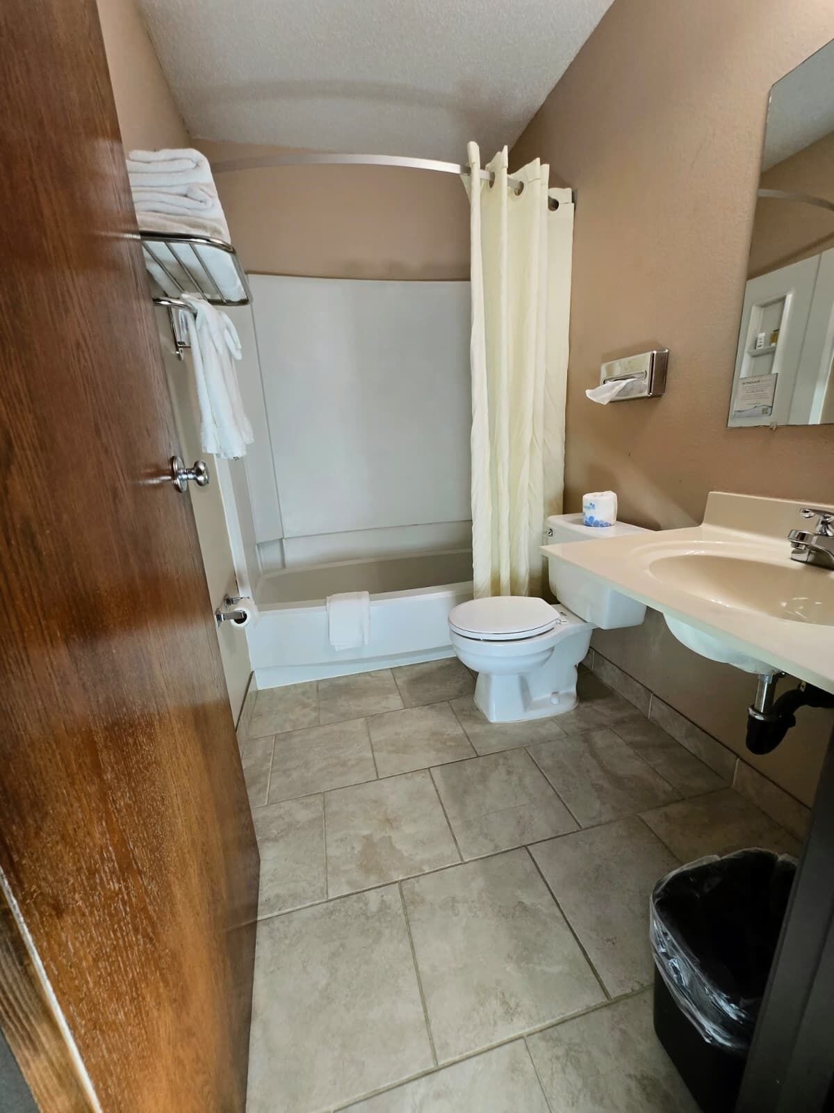 Une salle de bain avec des toilettes, un lavabo et un rideau de douche.