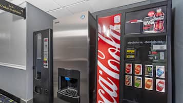 Máquina expendedora con logotipo de Coca-Cola y dispensador de agua.