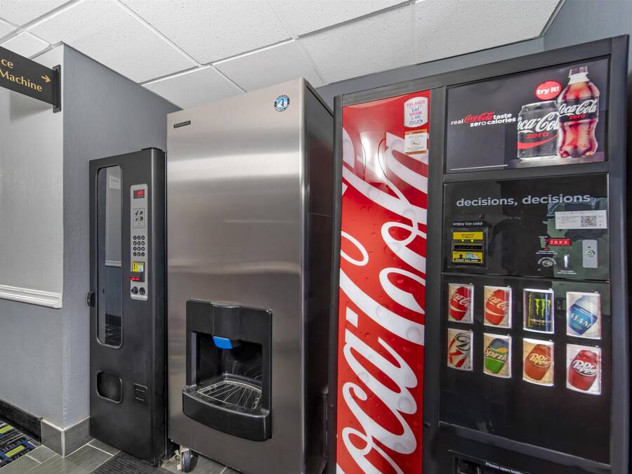 Máquina expendedora con logotipo de Coca-Cola y dispensador de agua.