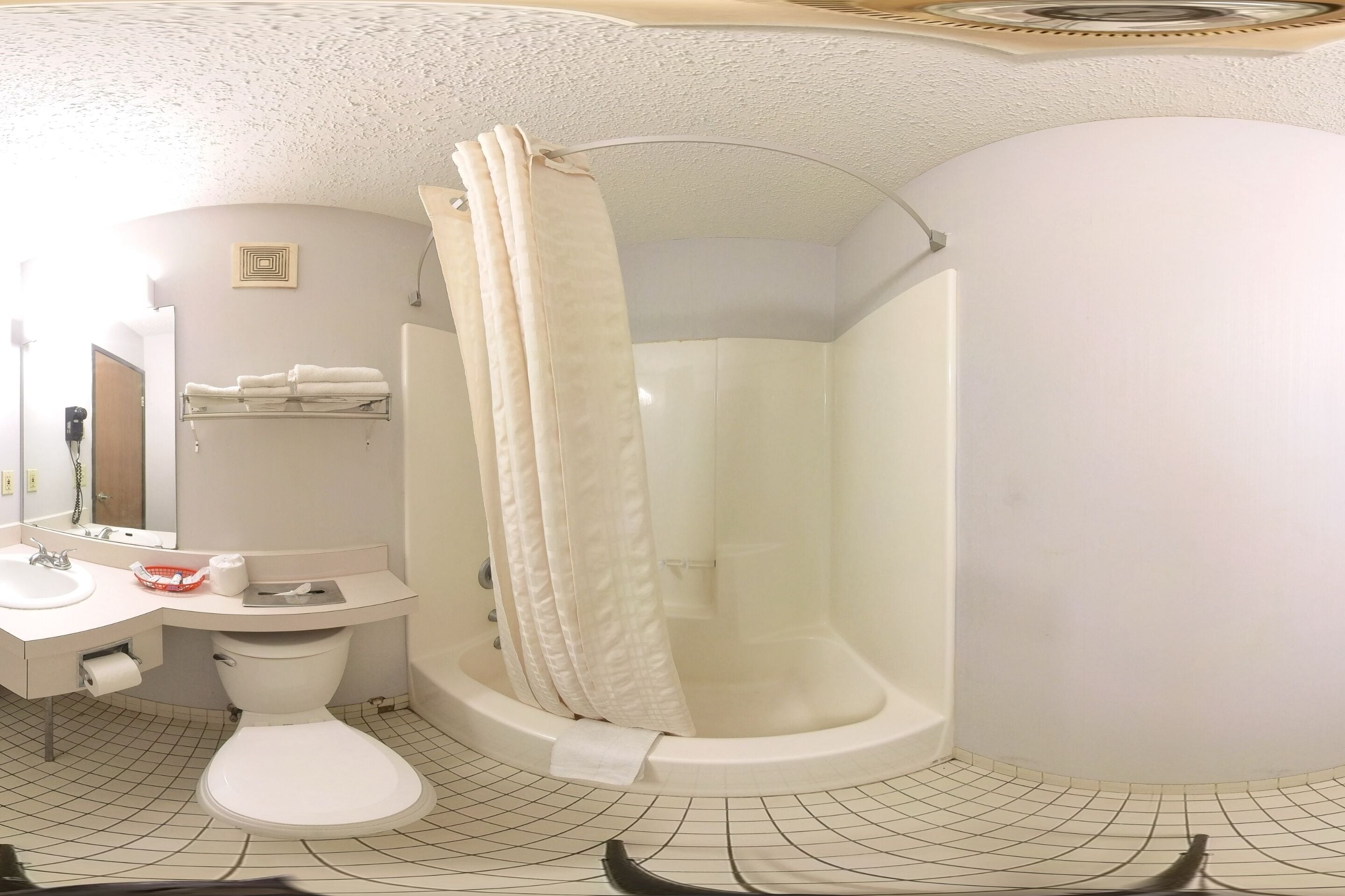 A bathroom with a toilet, sink, and shower area.