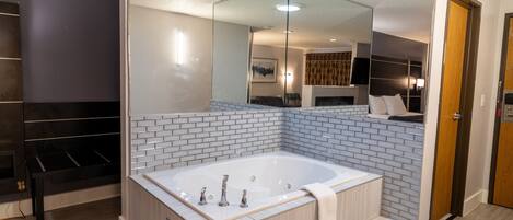 Un baño moderno con una bañera grande, un espejo y un tocador de madera.