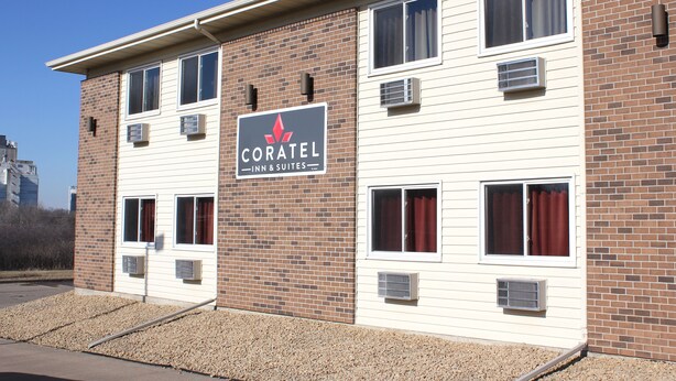 Il s'agit d'un hôtel dont l'enseigne indique « CORATEL INN & SUITES ». Il se distingue par sa façade en briques, dotée de nombreuses fenêtres et de plusieurs unités de climatisation.