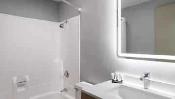 Un baño moderno con ducha, lavamanos y espejo.
