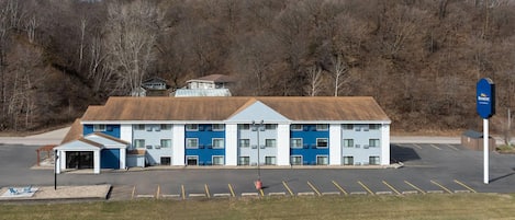 A motel with a parking lot, a covered entrance, and a sign for the brand 'Baymont.'