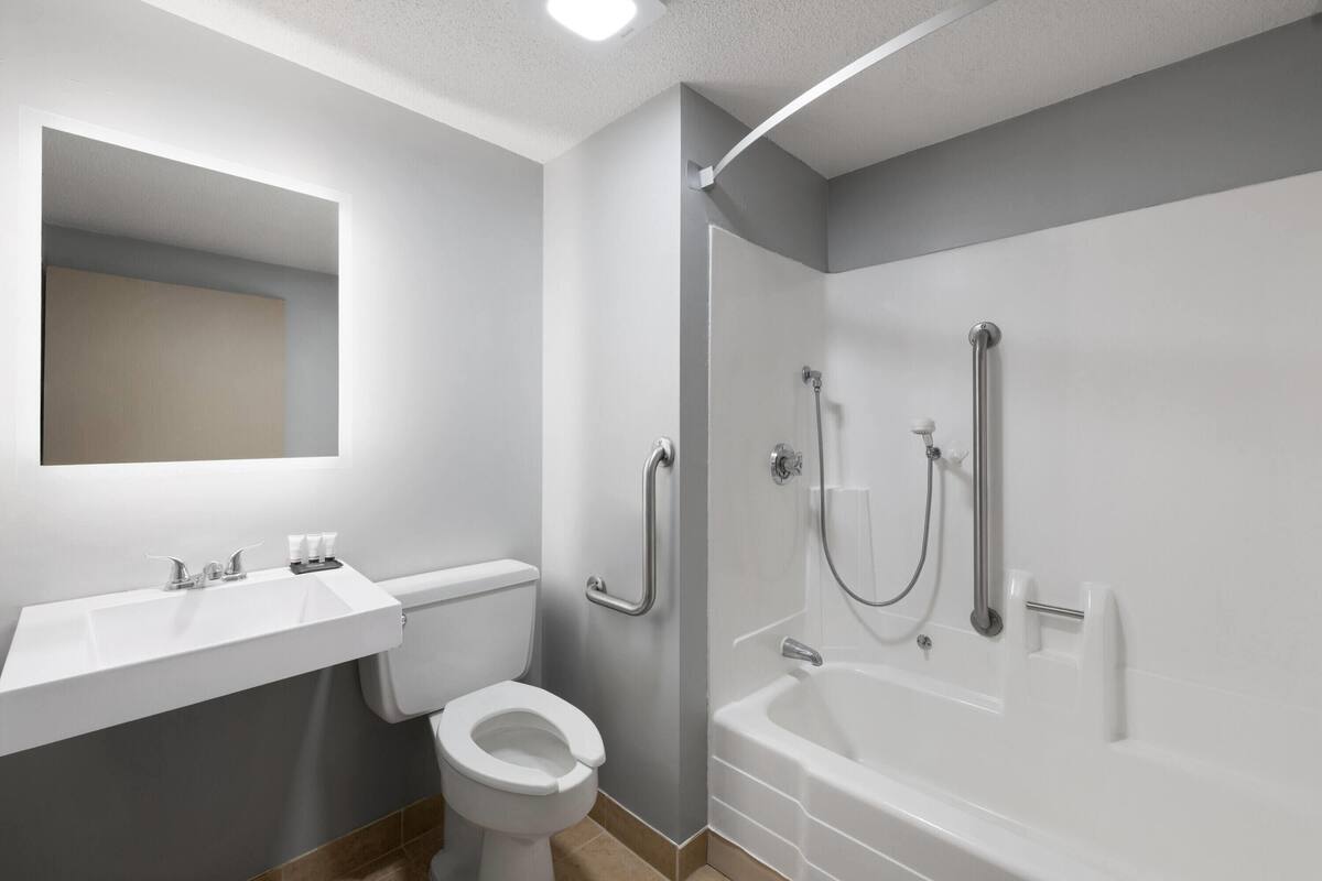 Een moderne badkamer met toilet, wastafel en bad.