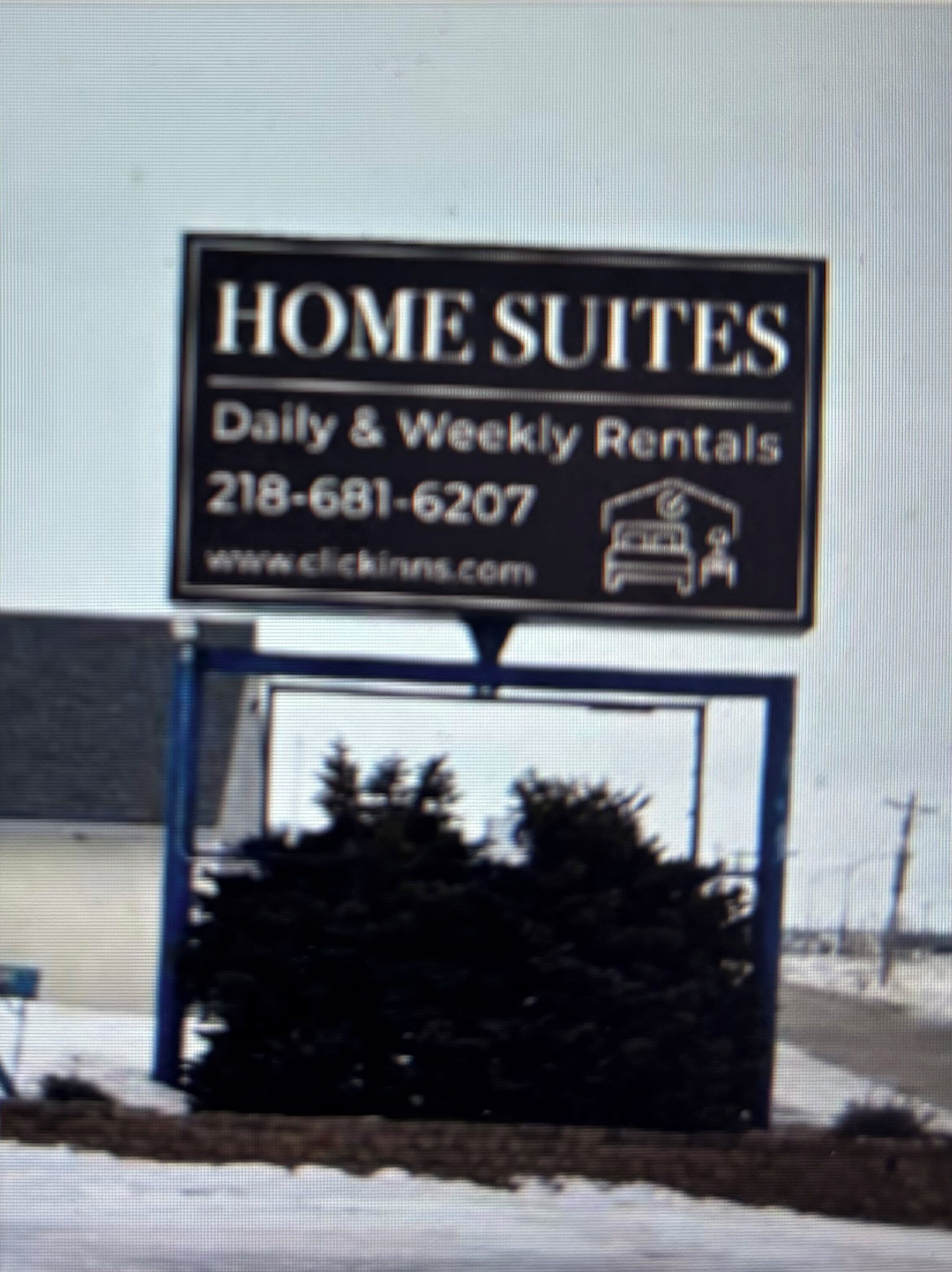 Señal de Home Suites que ofrece alquileres diarios y semanales, con un número de contacto y sitio web.