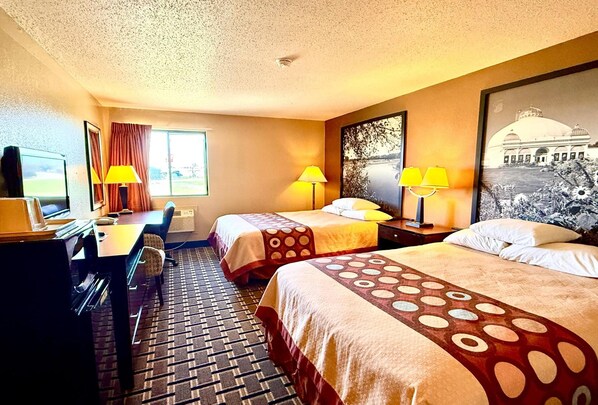 A hotel room with two beds, a desk with a computer, a chair, a TV, and a window with curtains. - Super 8 by Wyndham Melrose (Melrose)