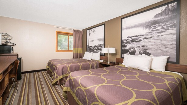 A hotel room with two beds, a desk, a chair, a lamp, and a large framed picture of a lake. - Super 8 by Wyndham St. Cloud (St Cloud)