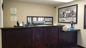 A reception desk with a computer, a phone, and a sign indicating check-in and check-out times. - Super 8 by Wyndham St. Cloud (St Cloud)