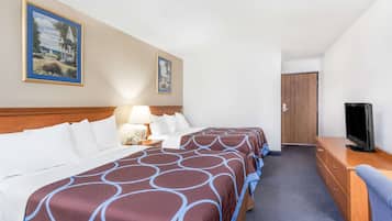 A hotel room with two beds, a TV, a desk, and a door.