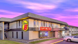 Un motel con un letrero de Super 8 y un letrero de Topp's Mideaway.