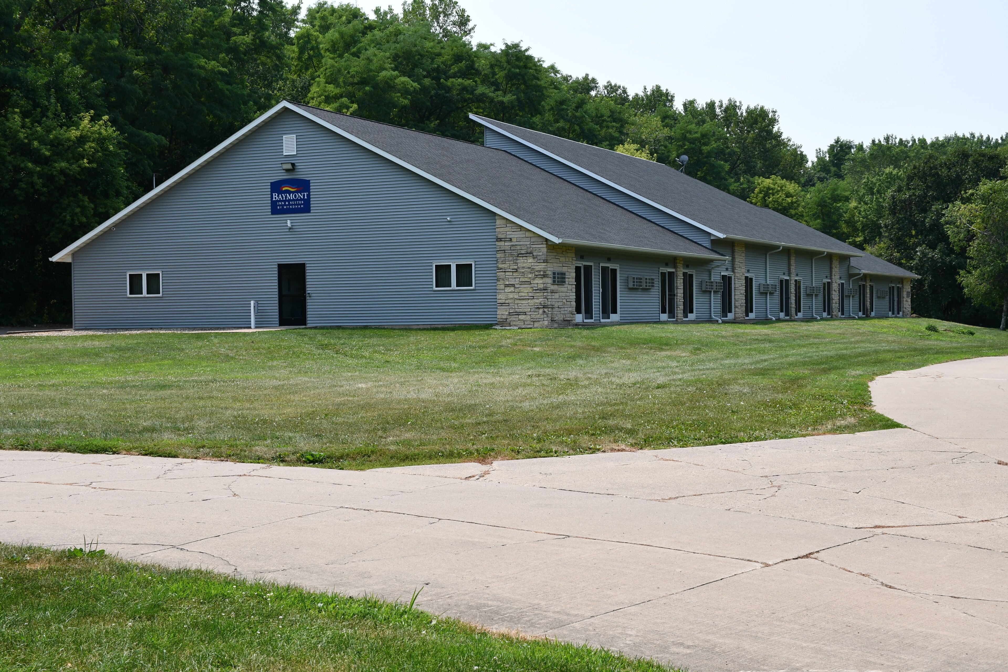 A Baymont Inn & Suites by Wyndham with a stone facade and a large parking lot.