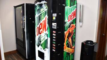 A vending machine with Mountain Dew branding and a person in a red outfit.
