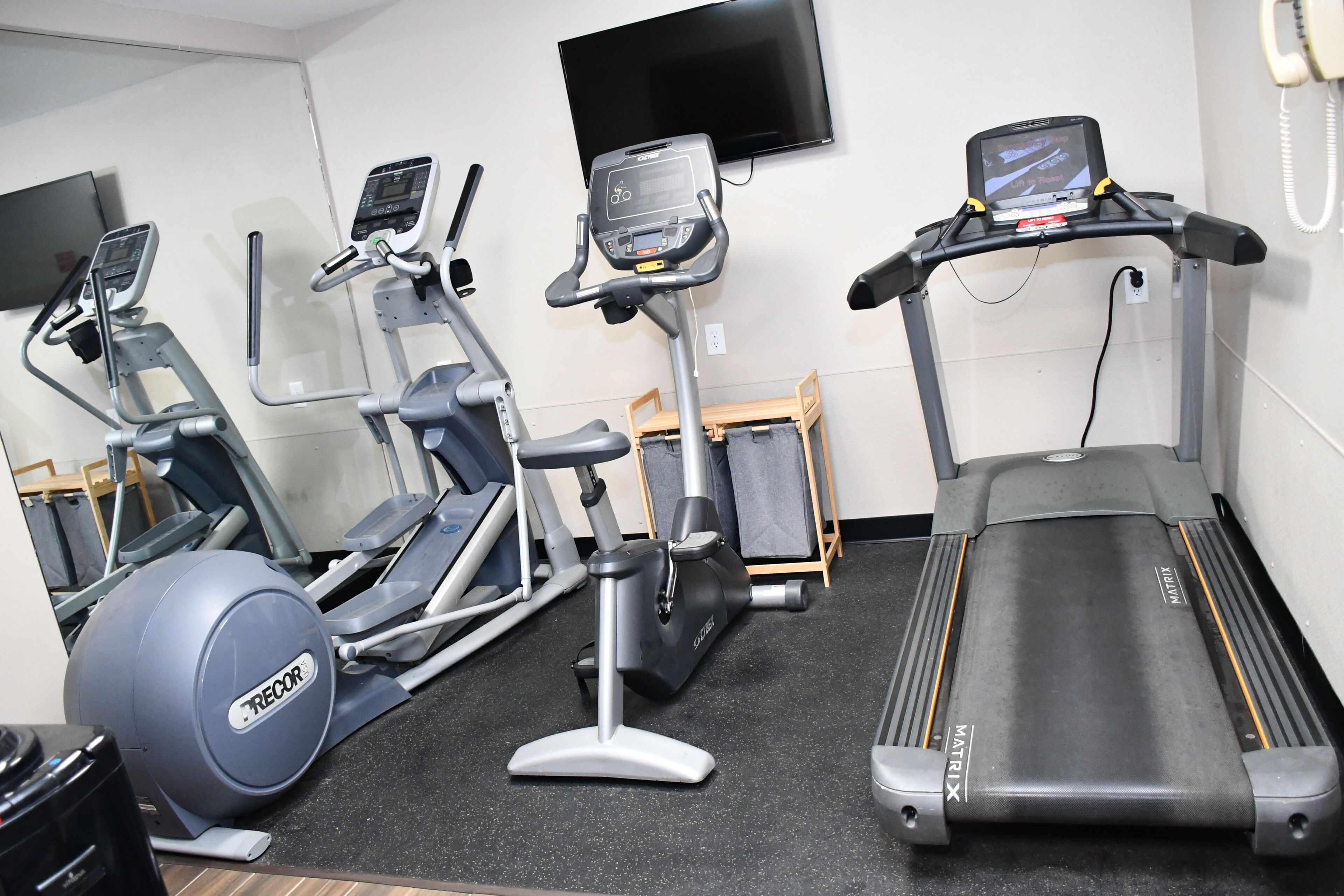 A gym with treadmills, an elliptical, and a stationary bike.