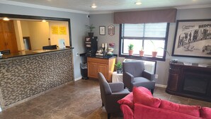 A reception area with a counter, a fireplace, and seating. - Super 8 by Wyndham Bedford (Bedford)