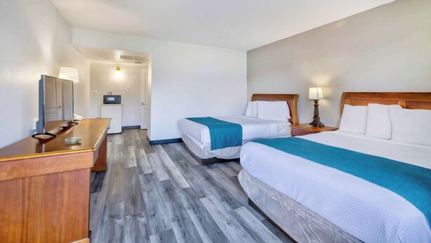 A hotel room with two beds, a wooden desk, a television, and a small kitchenette. - Motel 6 - Harrisburg, PA - Near PA Expo Center  (Harrisburg)