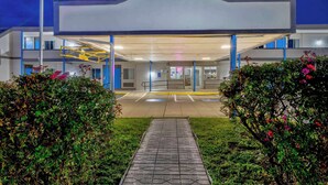 A modern building with a covered entrance, a parking area, and well-maintained landscaping. - Motel 6 - Harrisburg, PA - Near PA Expo Center  (Harrisburg)