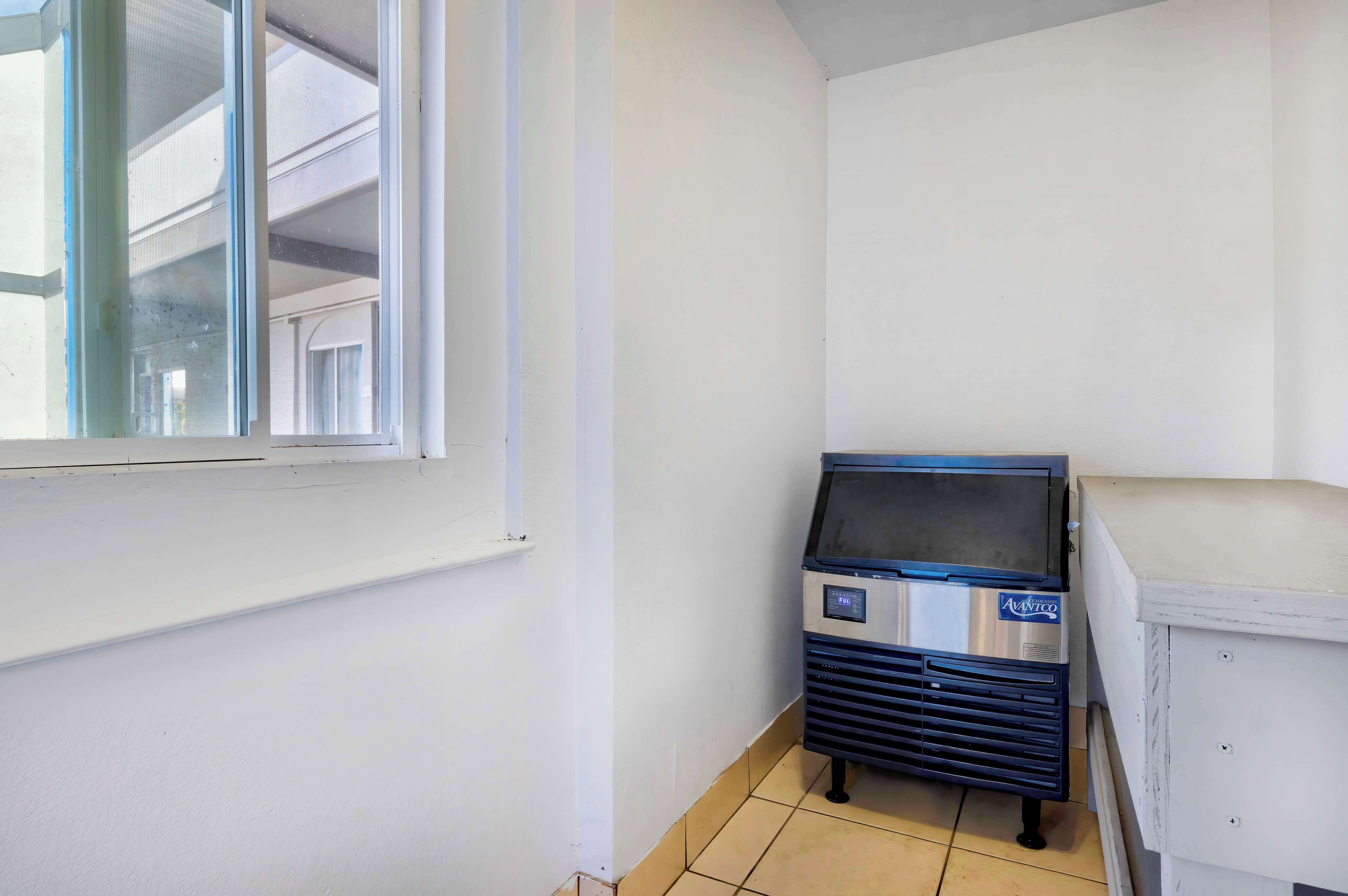 Une pièce avec une fenêtre, un distributeur automatique et un meuble blanc.