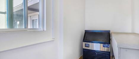 Une pièce avec une fenêtre, un distributeur automatique et un meuble blanc.