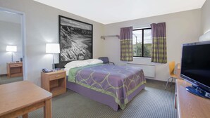 A hotel room with a bed, a desk, a TV, a window with curtains, and a painting on the wall. - Super 8 by Wyndham Havre (Havre)