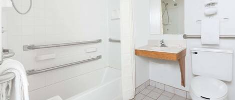 Casa de banho moderna com chuveiro, sanita e lavatório. Inclui barras de apoio e suporte para toalhas.