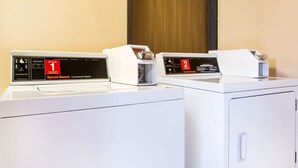 Twee commerciële wasmachines, waarvan één met een digitaal scherm met de aanduiding 'Speed Queen' en de andere met 'Speed Runner'.