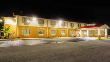 A multi-story hotel with a red-roofed entrance and a parking lot.