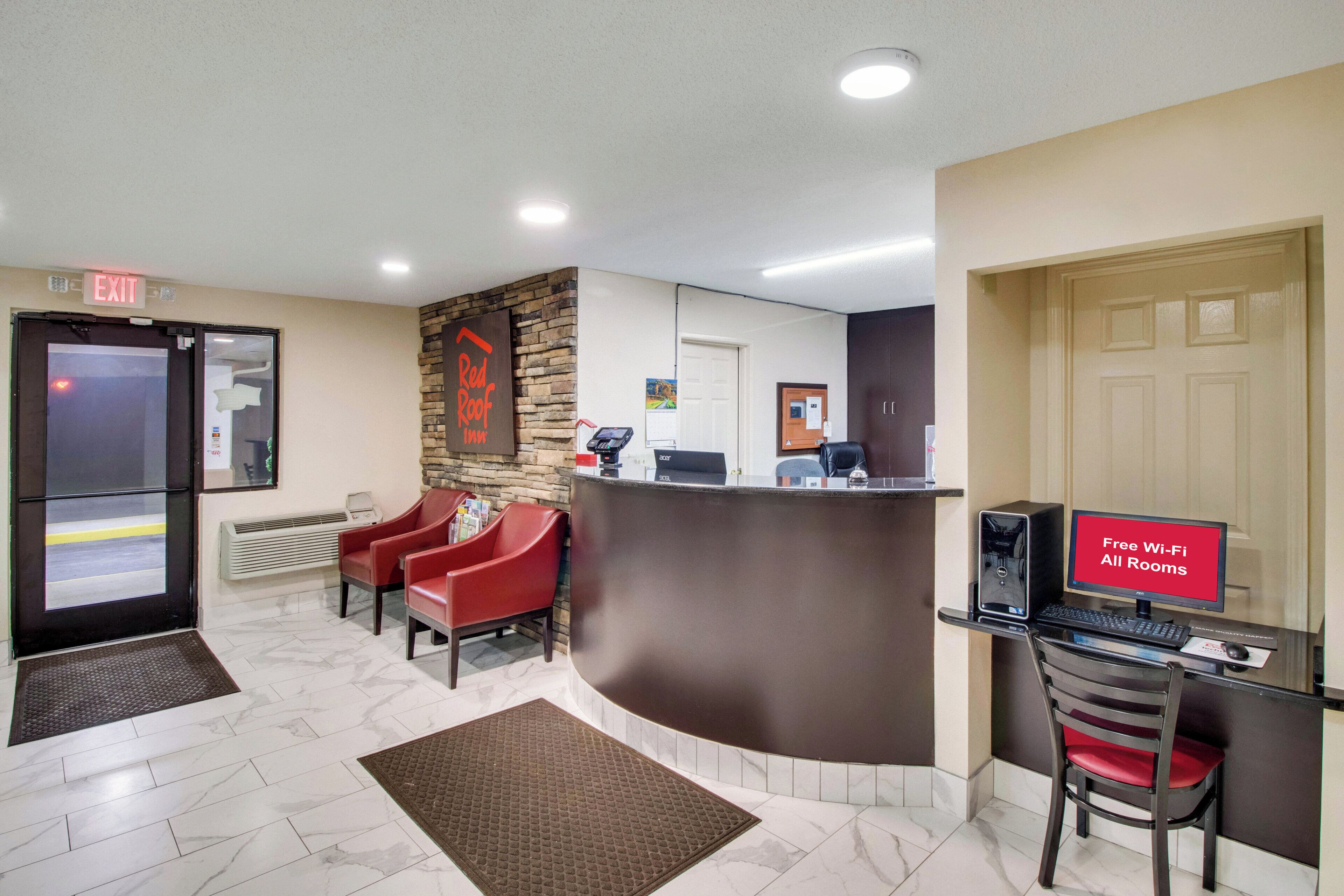 A reception area with a desk, computer, and a sign indicating free Wi-Fi and all rooms.