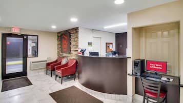 A reception area with a desk, computer, and a sign indicating free Wi-Fi and all rooms.