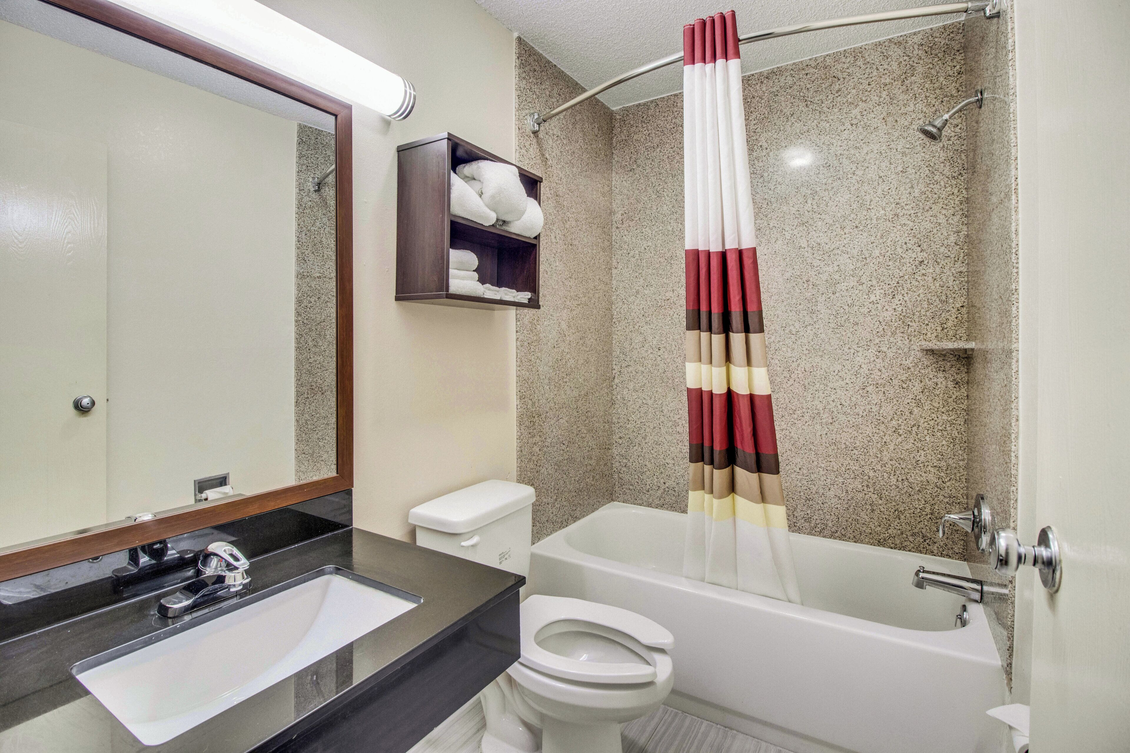 A bathroom with a sink, toilet, bathtub, and a shower curtain.
