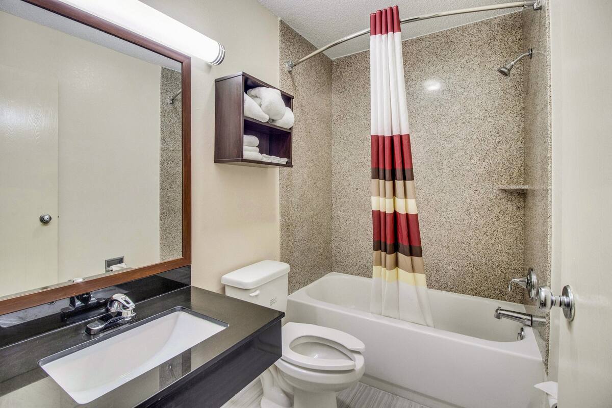 A bathroom with a sink, toilet, and bathtub.