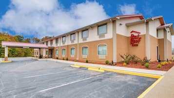 Un Red Roof Inn con estacionamiento y una pasarela techada.
