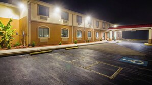 A multi-story hotel with a covered parking area and a handicapped accessible parking space. - Red Roof Inn Franklin, KY (Franklin)
