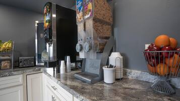 Eine Küchenzeile mit Kaffeemaschine, Toaster und Obstkorb.