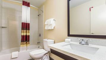 A bathroom with a bathtub, toilet, and sink.