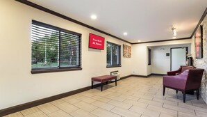 A hotel lobby with a flat-screen TV displaying 'Free Wi-Fi All Rooms,' a bench, a fireplace, and a seating area with chairs. - Red Roof Inn Dry Ridge (Dry Ridge)