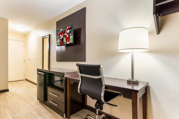 A hotel room with a desk, a chair, a lamp, a TV, and a microwave. - Red Roof Inn Dry Ridge (Dry Ridge)