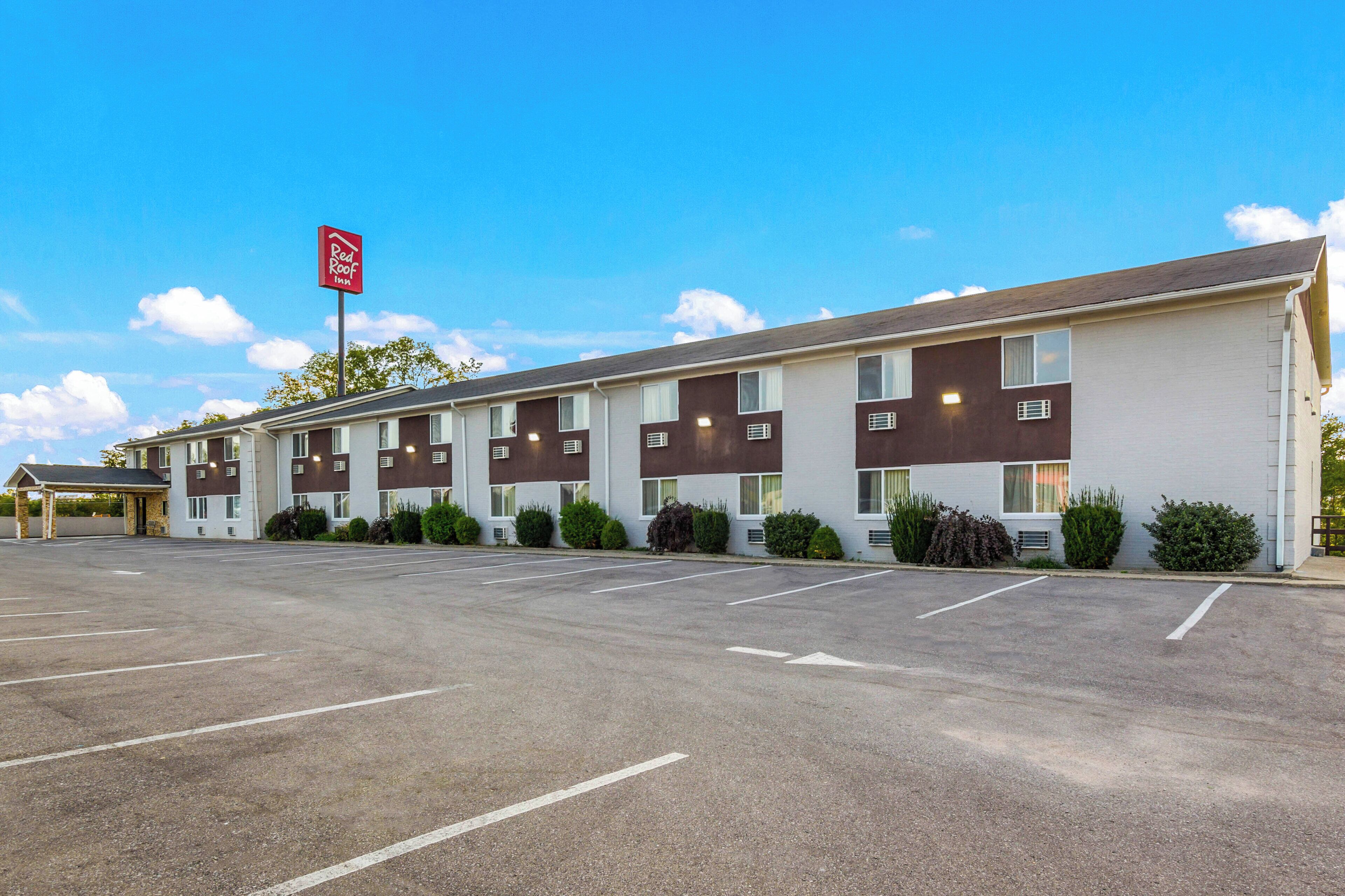 Red Roof Inn -hotelli, jossa on pysäköintialue ja katettu sisäänkäynti.