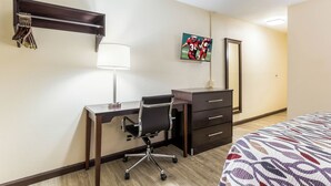 A hotel room with a desk, chair, bed, bedside table, lamp, and a mirror. - Red Roof Inn Dry Ridge (Dry Ridge)