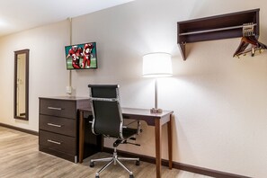 A hotel room with a desk, chair, TV, lamp, and a coat rack. - Red Roof Inn Dry Ridge (Dry Ridge)