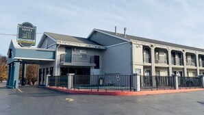 A two-story building with a sign for Economy Suites, indicating extended stay and full kitchenette amenities.